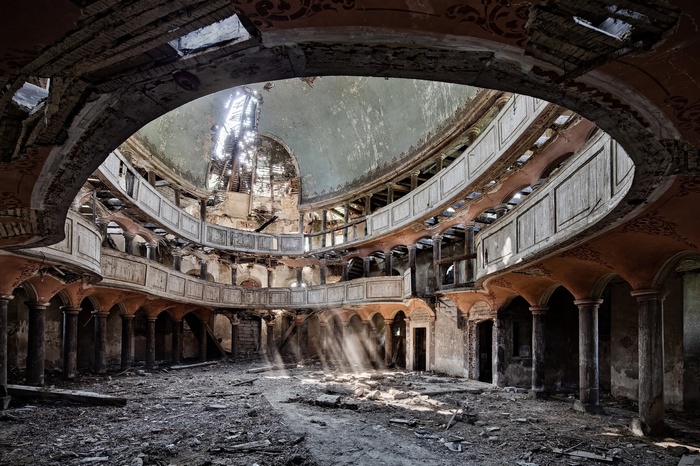 Abandoned building interior with dome and sun rays