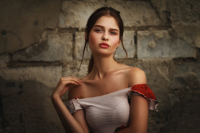 Woman with dark hair in a white off-the-shoulder top