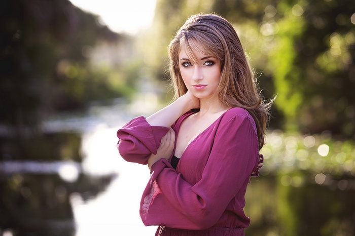 Woman in purple clothing looking at viewer outdoors