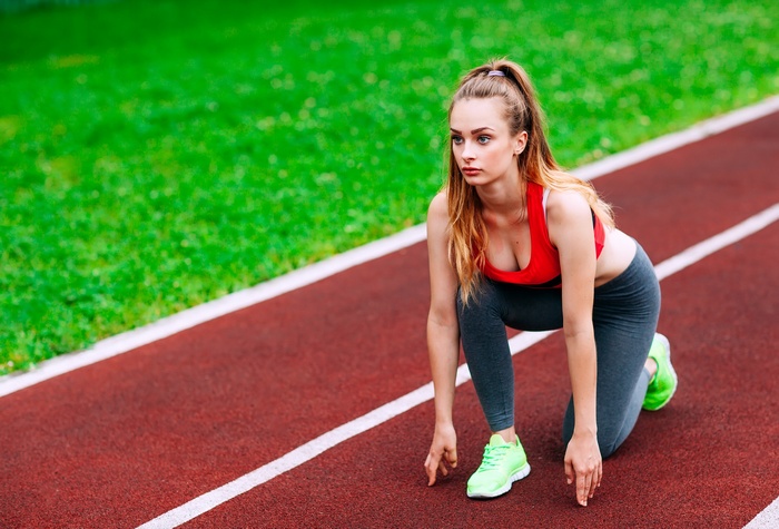 Woman in athletic wear at starting line on track