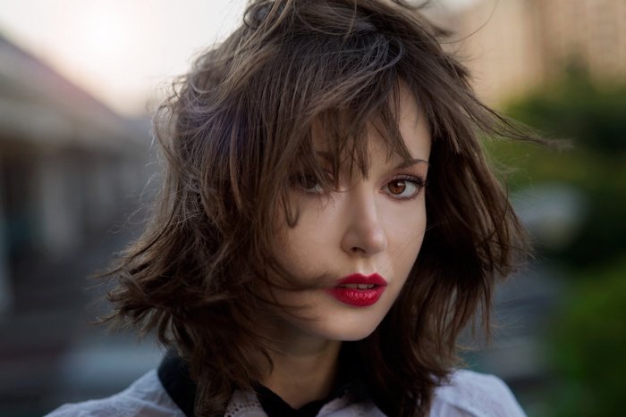 Woman with messy brown hair and red lipstick