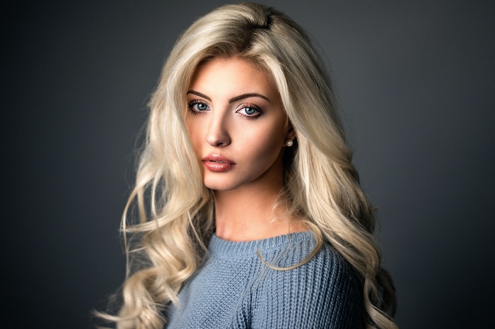 Woman with blonde hair wearing a blue sweater