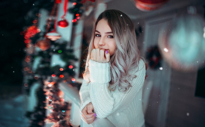 Woman in white sweater with Christmas decorations