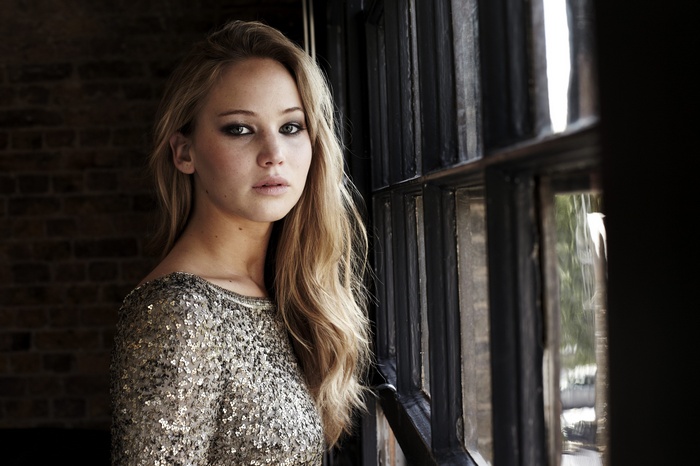 Jennifer Lawrence in a sequined top by a window