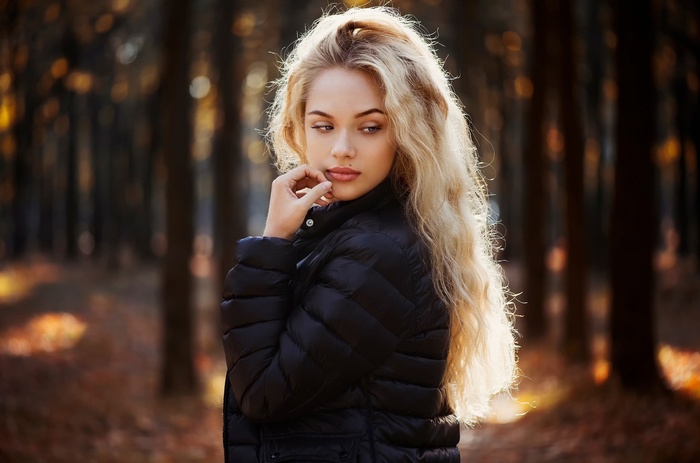 Ann Nevreva in a black jacket in a forest
