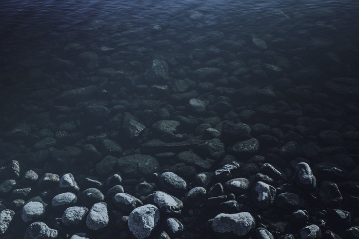 Dark water over submerged rocks