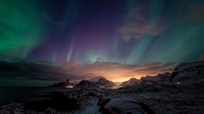 Aurora Borealis over snowy mountains and coast