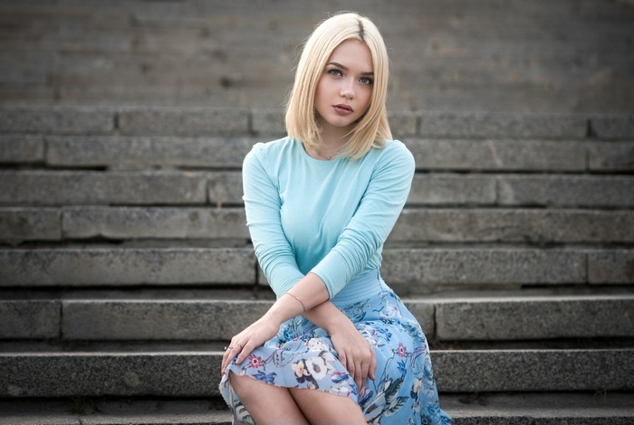 Blonde woman sitting on stone steps
