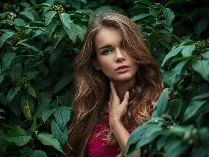 Portrait of a woman surrounded by green leaves