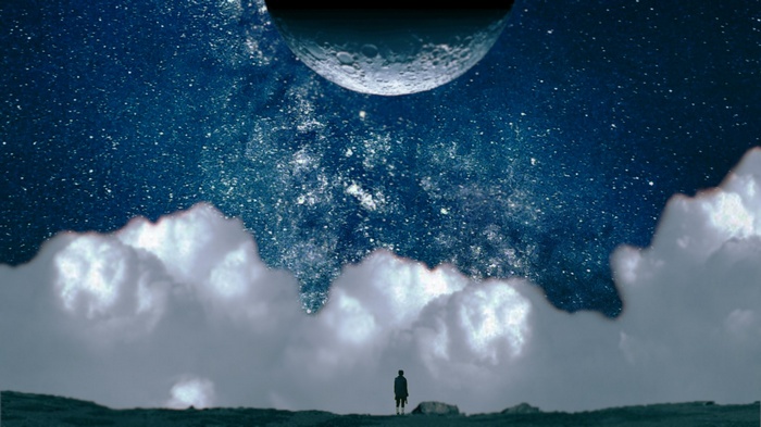 Man standing under a surreal night sky with moon and clouds