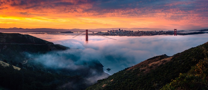 Golden Gate Bridge shrouded in fog at sunrise