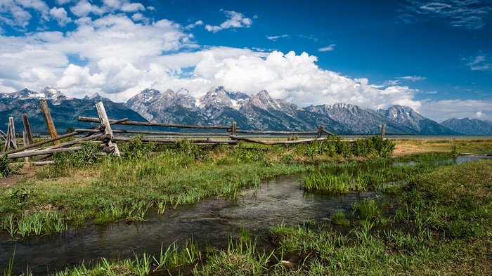 Grand Teton Mountains with a wooden fence and stream