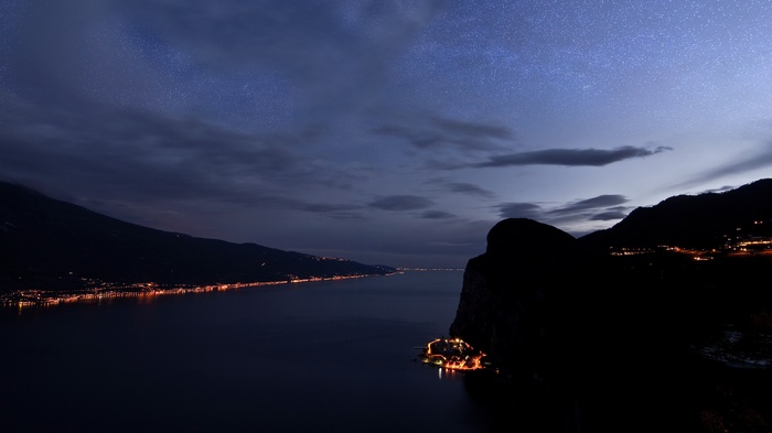 Night view of a lake with mountains and stars