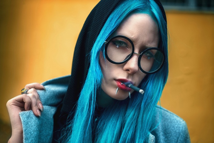Woman with blue dyed hair smoking a cigarette