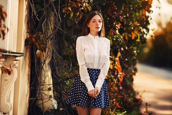 Olga Kobzar posing in a white shirt and polka dot skirt