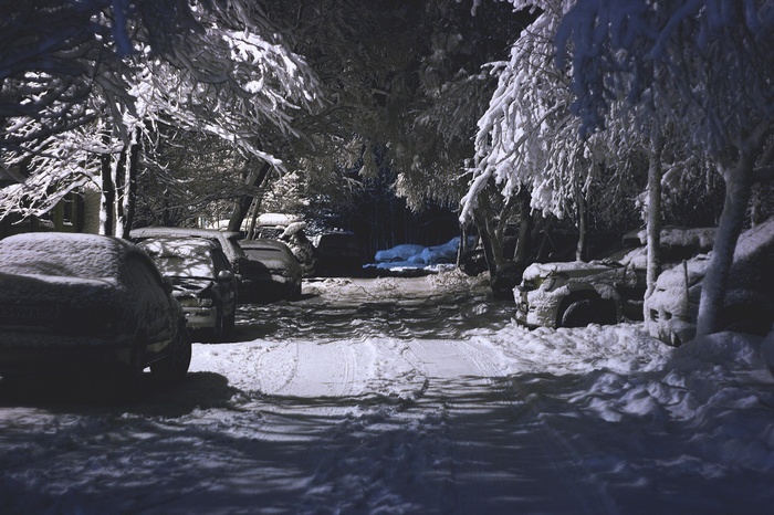Cars parked on a snowy street at night