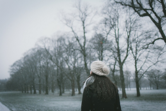 Woman in a knitted hat in a snowy park