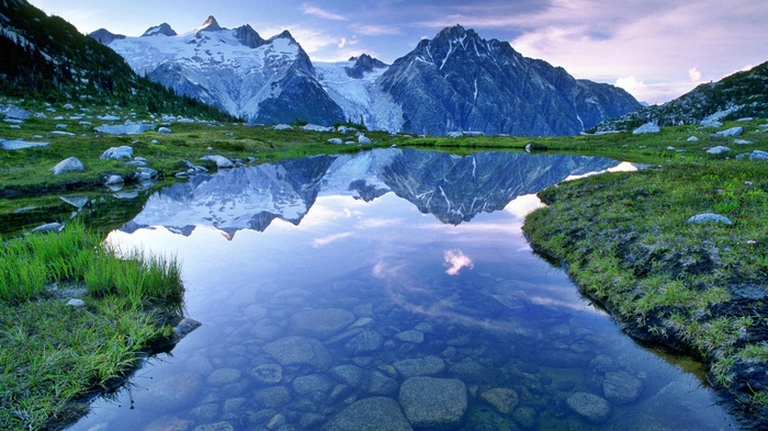 Snow-capped mountains reflected in a clear lake