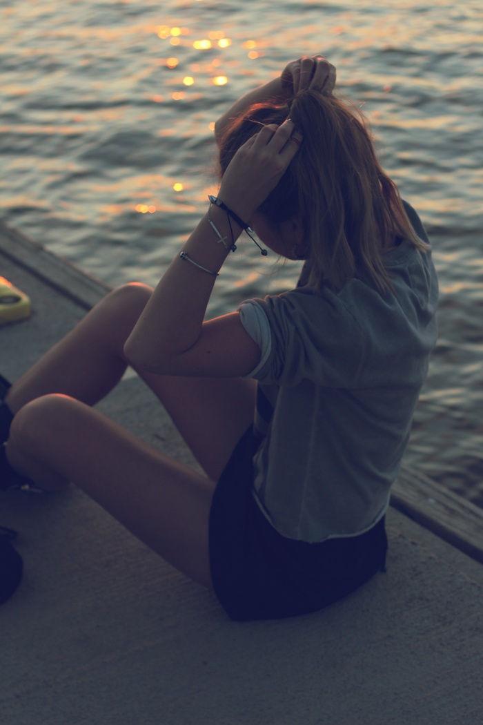 Girl tying her hair by the water
