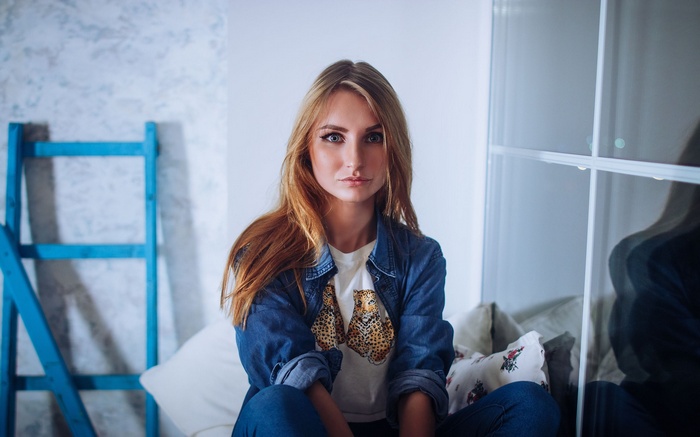 Margarita Zeziulia in denim and T-shirt by the window