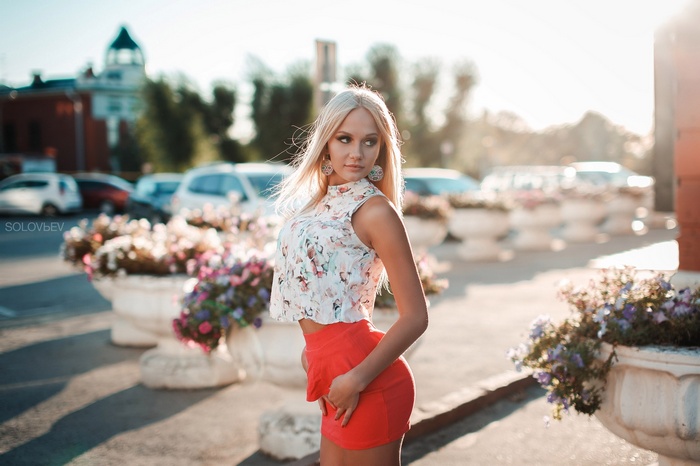 Woman in floral top and red skirt outdoors