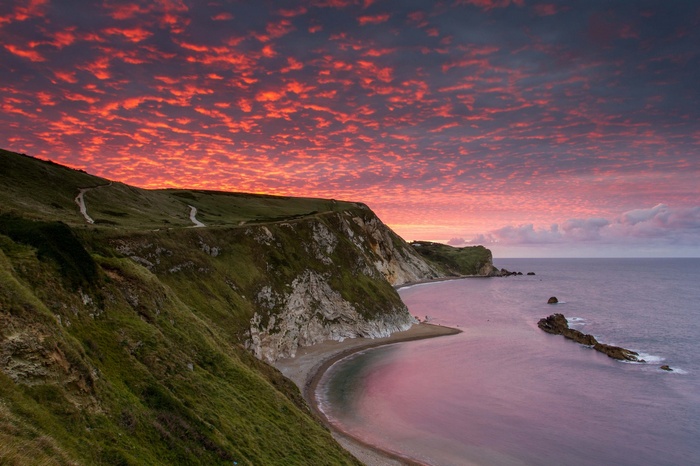 Dramatic sunset over a coastal cliffside landscape