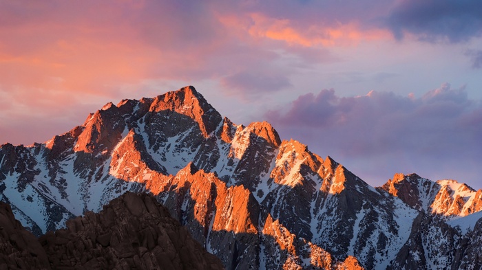Snow-capped mountains at sunset with colorful clouds