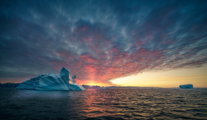 Iceberg in the ocean during sunset