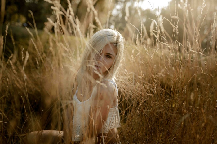 Woman with blonde hair in a field of tall grass