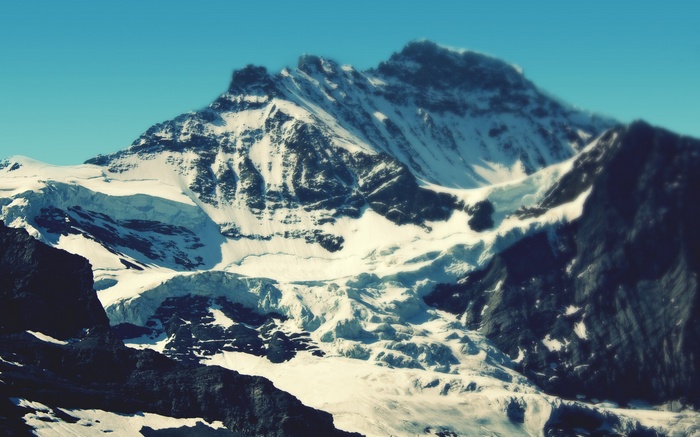 Snow-covered mountains under a clear blue sky