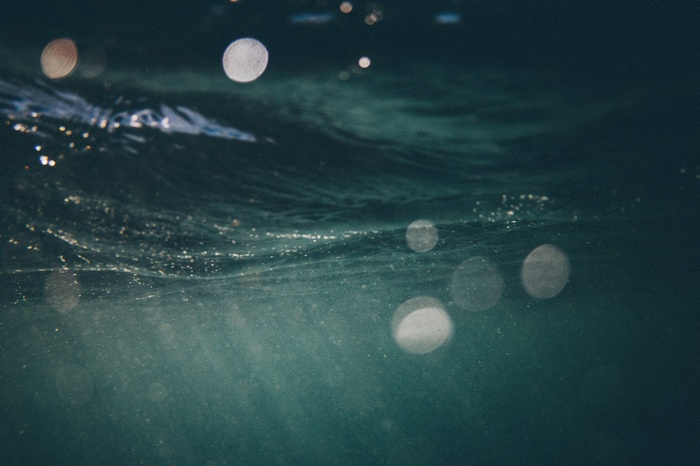 Underwater view of dark blue water with light reflections