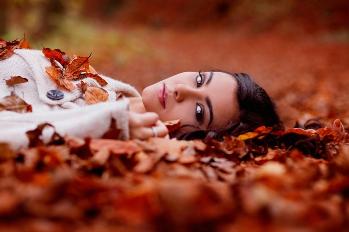 Woman lying down in autumn leaves