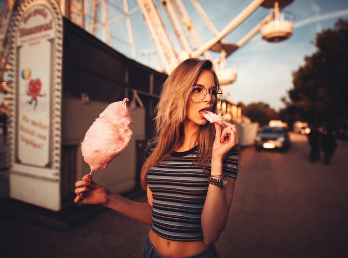 Woman eating cotton candy at amusement park