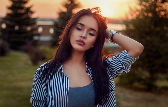 Woman with closed eyes at sunset