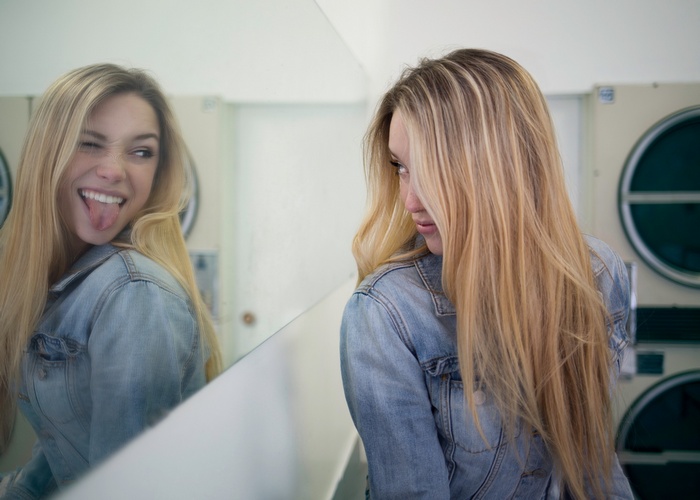 Alexis Ren sticking her tongue out in a mirror