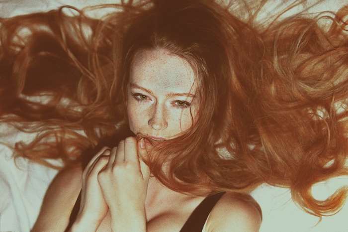 Redhead woman with freckles lying down