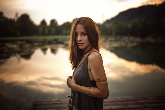 Woman with pierced nose by a lake at sunset