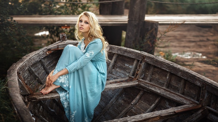 Woman in blue dress sitting in a boat