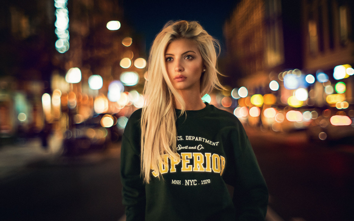 Woman with blonde hair in a city at night