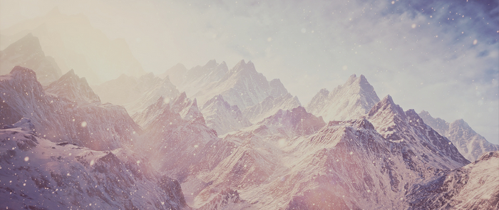 Snowy mountain range with falling snow