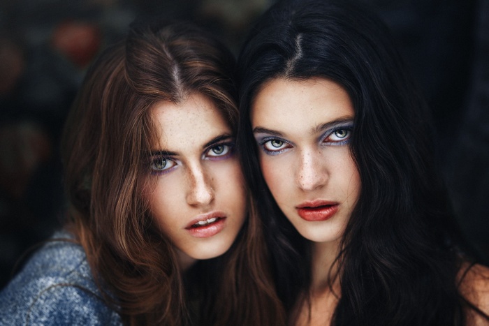 Two women with freckles and dramatic makeup