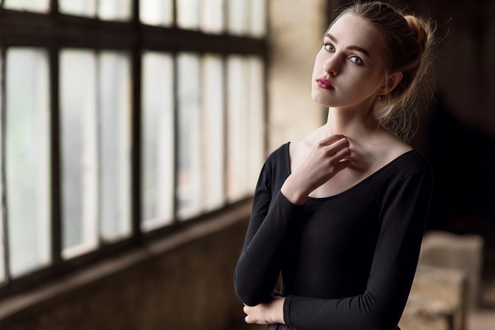 Woman in black leotard by window