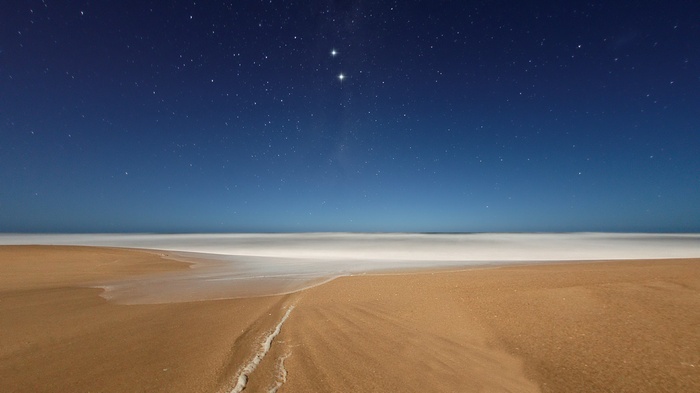 Beach at night with stars and ocean