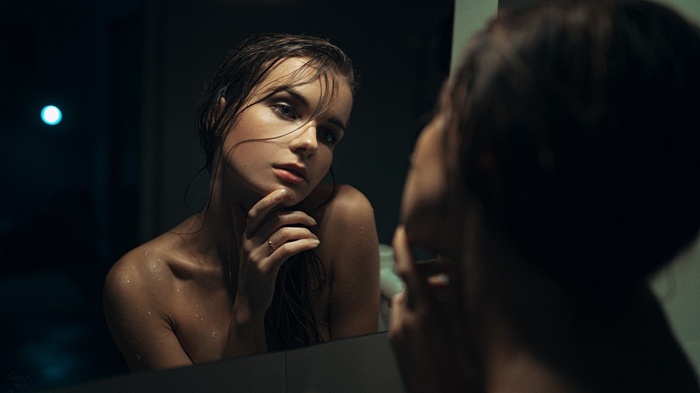 Woman with wet hair looking in the mirror