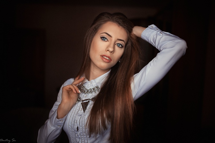 Portrait of a woman with long brown hair and blue eyes