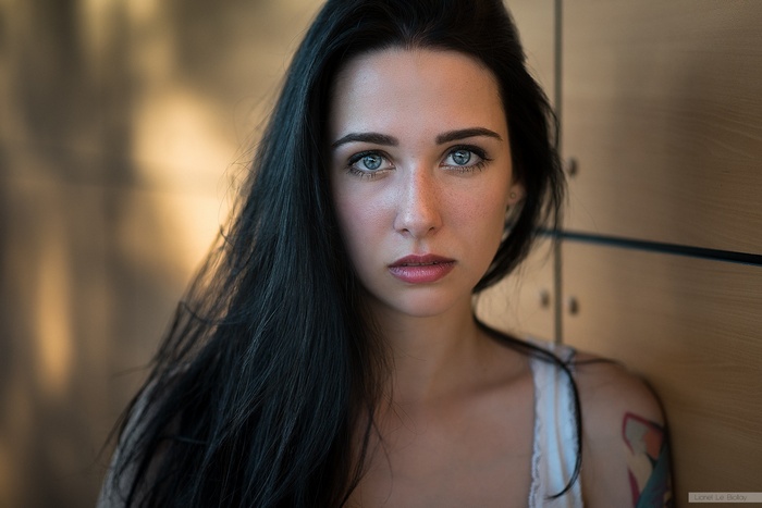 Portrait of a woman with black hair and tattoos by Lionel Le Biollay