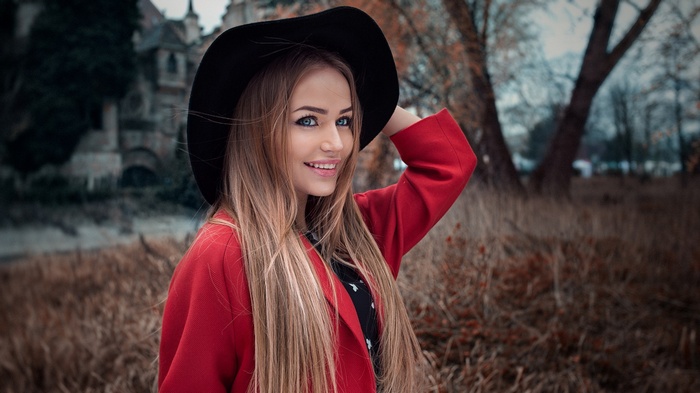 Woman in red coat and black hat outdoors