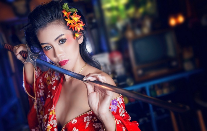 Asian woman in kimono holding a sword