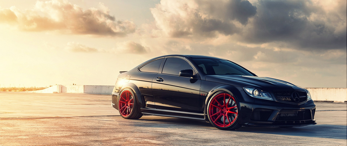 Black Mercedes-Benz C63 AMG Coupe with red wheels