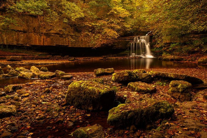 Waterfall in a forest during autumn with mossy rocks